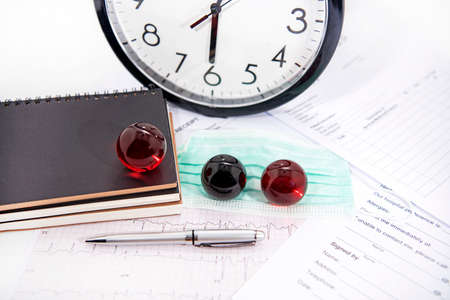 Medicine documents with small glass balls on it. Abstract photo of illness time.の写真素材