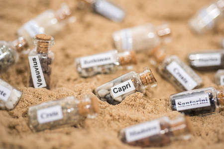 Glass test-tube with sand of different summer vacation countries.