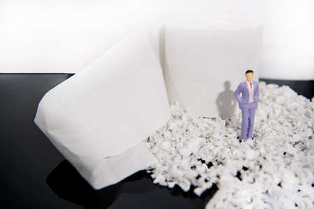 Abstract photo with toilet paper and some small people figures. Waste of time concept.の写真素材