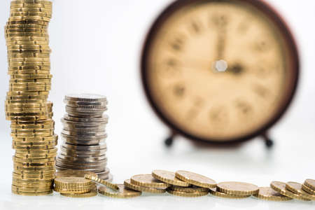 TIME IS MONEY concept: Alarm clock and with coins