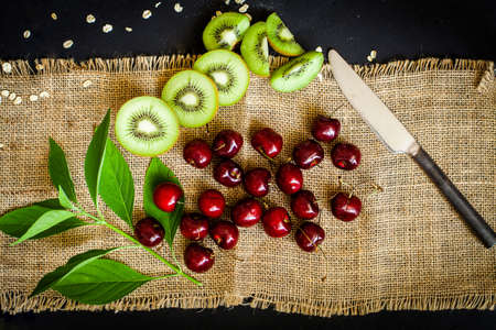 Organic kiwi & Cherry fruit isolated on the black backgroundの写真素材
