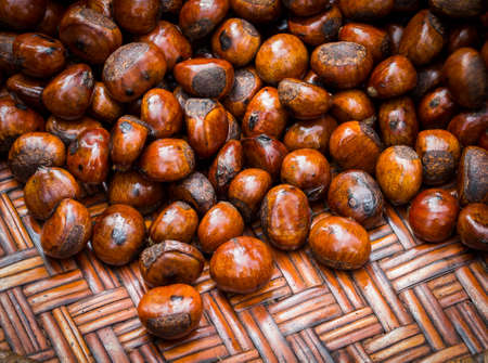 Roasted chestnuts in burlap bag on wooden backgroundの写真素材