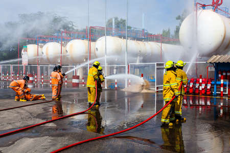 Fire fighter in full gear standing outside a steel building ready to go in.のeditorial素材