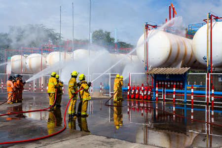 Fire fighter in full gear standing outside a steel building ready to go in.