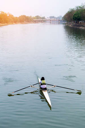 Rear view of kayaker  paddle kayak at sunsetの写真素材