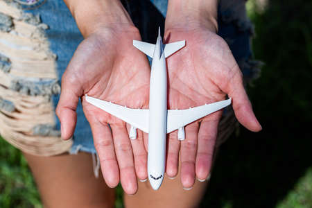 Airplane model in hand on sunny sky. Concepts of travel, transportationの写真素材