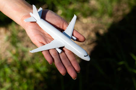 Airplane model in hand on sunny sky. Concepts of travel, transportationの写真素材