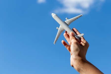 Airplane model in hand on sunny sky. Concepts of travel, transportationの写真素材