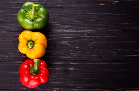 Three sweet peppers on a wooden background, Cooking vegetable saladの写真素材