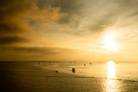 Sunset over the water with cloudy skyの写真素材