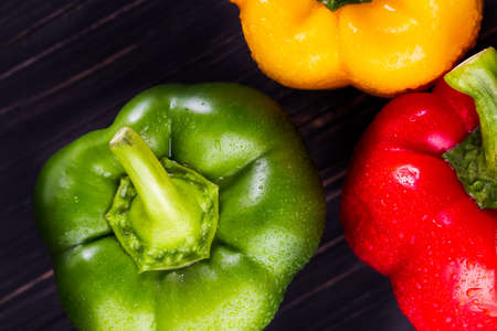 Three sweet peppers on a wooden background, Cooking vegetable saladの写真素材
