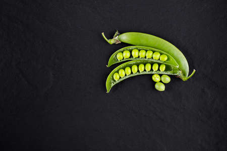 Sugar snap peas with mint on a rustic wood background