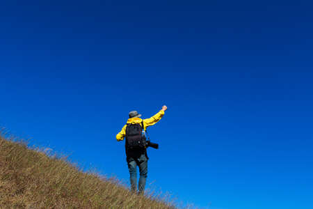 Silhouette of man hold up hands on the peak of mountain,success conceptの写真素材