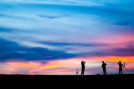 Silhouette of man hold up hands on the peak of mountain,success conceptの写真素材