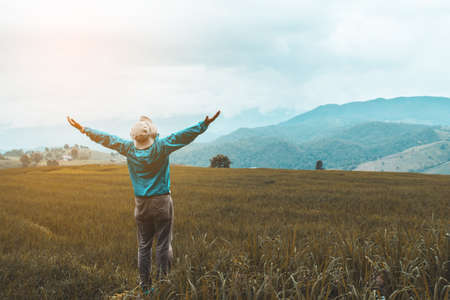 Young boy relaxing in green rice terraces on holiday