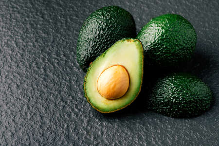Fresh sliced avocado on wooden table. Vegetarian food concept.