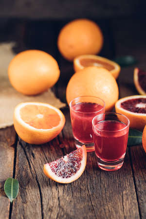 Sliced Sicilian Blood oranges fruits over old dark wooden background. Top view.の写真素材