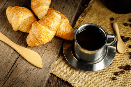 Coffee and croissants on the wooden background, top viewの写真素材