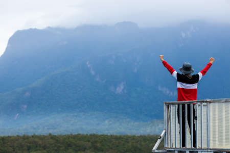 Silhouette of man hold up hands on the peak of mountain,success concept