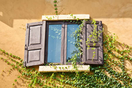 vintage old wooden window on yellow wall