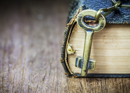 conceptual image, metal key with old book on wooden background, copy spaceの写真素材