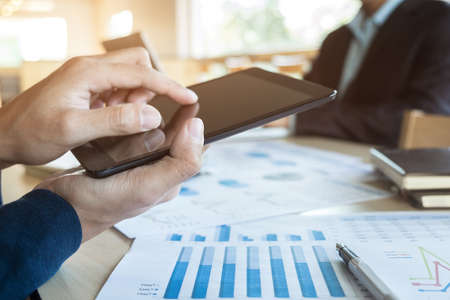 Team job succes. Closeup photo young hands business managers holding tablet working with new startup project in office.Analyze document plan.の写真素材