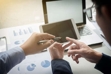Teamwork process, Young businessmen hands pointing at tablet during explanation of new plan project data at meeting.の写真素材