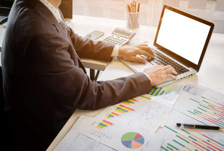 Close up of hand of business man working document and laptop in office morning light. business concept.の写真素材