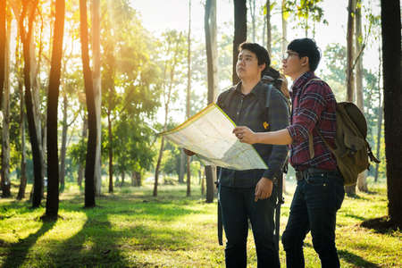 Two Young Man Traveler with backpack handle map relaxing outdoor on background Summer vacations and Lifestyle hiking concept.の写真素材