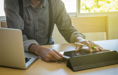 Image of young businessmen using touchpad at office in the morning.