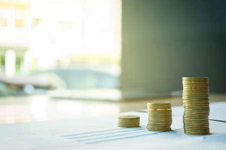 stack of coin on business document graph. Money and financial concepts.の写真素材