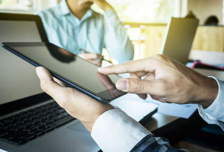 Business teamwork process, Businessmen hands pointing at tablet and document during explanation of new plan project data at meeting.の写真素材