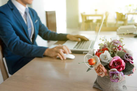 Young man working with laptop on his desk in coffee cafe, man's hands on notebook computer, business person at workplace.の写真素材