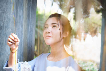 portrait of confident flirting woman with sexy looking creep plant in hands under sunlightの写真素材