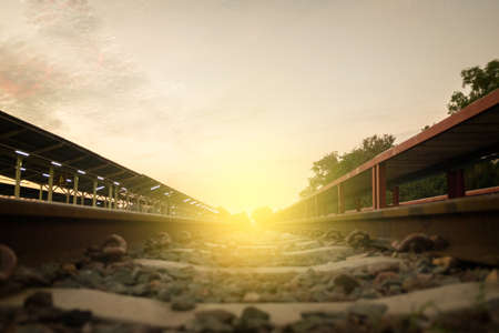 railway track on gravel for train transportation and light sunset in the morning.の写真素材