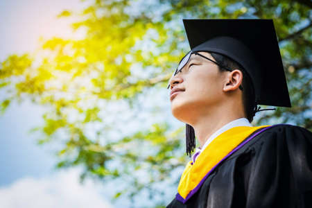A graduate in the mantle looks up and thinks of a great future. handsomel graduate boy with...