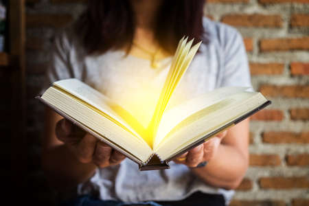 Woman holding and reading book.