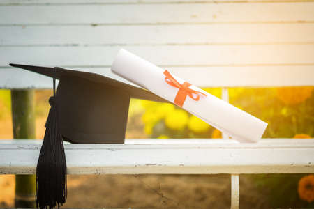 Graduation cap, Hat with degree paper on white wood table, abstract light background Empty ready for your product display or montage.の写真素材