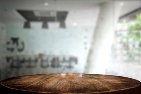 Selected focus empty brown wooden table and meeting room or office work blur background image. for your photomontage or product displayの写真素材