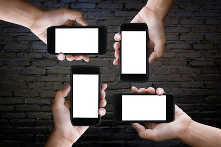 hands holding blank screen of a smartphone at the old black brick wall.の写真素材