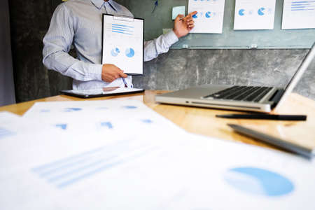Business executive making presentation to colleagues in office, during meeting, explaining,...