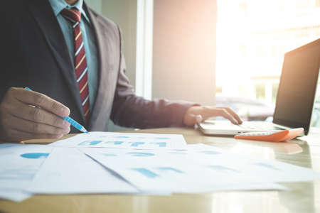 Business concept, Young business man's hands working with laptop and document graph on wood table.の写真素材