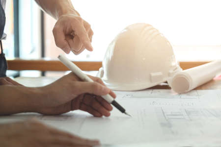 Image of engineer or architectural project, Close up of hands architects engineering working on blueprint with engineering equipment tool, Construction concept.の写真素材