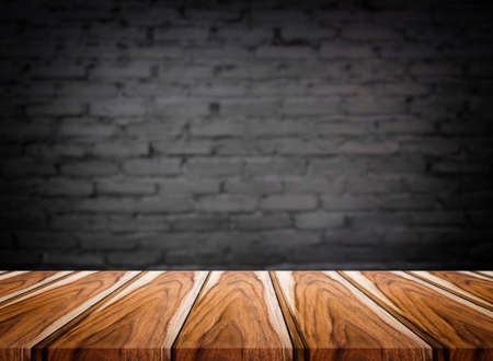 Selected focus empty brown wooden table and wall texture or old black brick wall blur background...