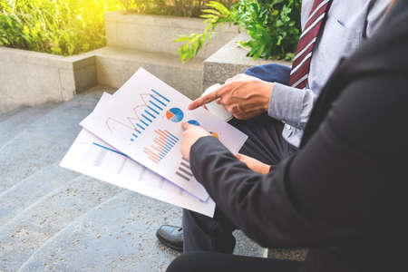 Business team two colleagues being discussing the new project financial plan on digital tablet outdoor.の写真素材