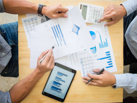 Two businessman calculating Tax Invoice, new project business strategy plan graph and using...