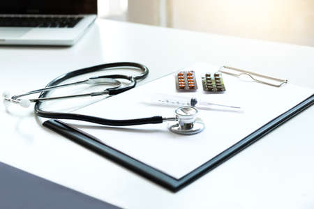 View of stethoscope, drug and equipment on foreground table with computer laptop, Health care and Medical concept.の写真素材