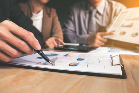 Co working conference, Business team meeting present, investor colleagues discussing new plan financial graph data on office table with laptop and digital tablet, Finance, accounting, investment.の写真素材