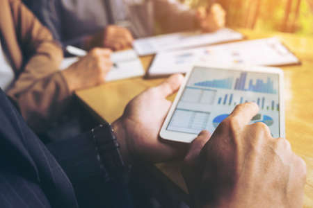 Co working conference, Business team meeting present, investor colleagues discussing new plan financial graph data on office table with laptop and digital tablet, Finance, accounting, investment.の写真素材