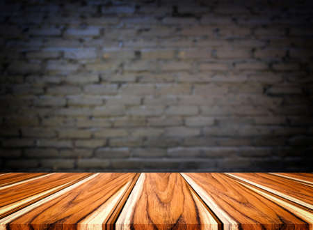 Selected focus empty brown wooden table and wall texture or old black brick wall blur background...